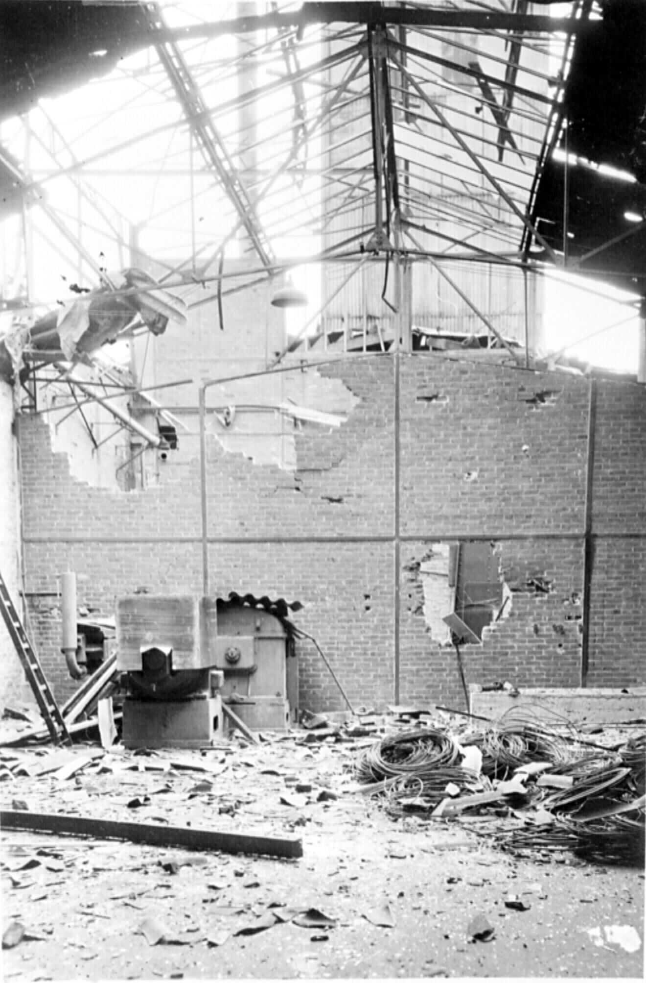 Photographie en noir et blanc de l'intérieur d'une usine détruite par la Résistance