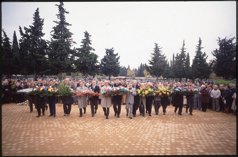 Le maire de Montpellier Georges Frêche et des rapatriés déposent une gerbe devant la stèle érigée "à la mémoire des morts restés sur la terre d'Afrique" dans le cimetière de Montpellier lors de la cérémonie du 1er novembre 1992