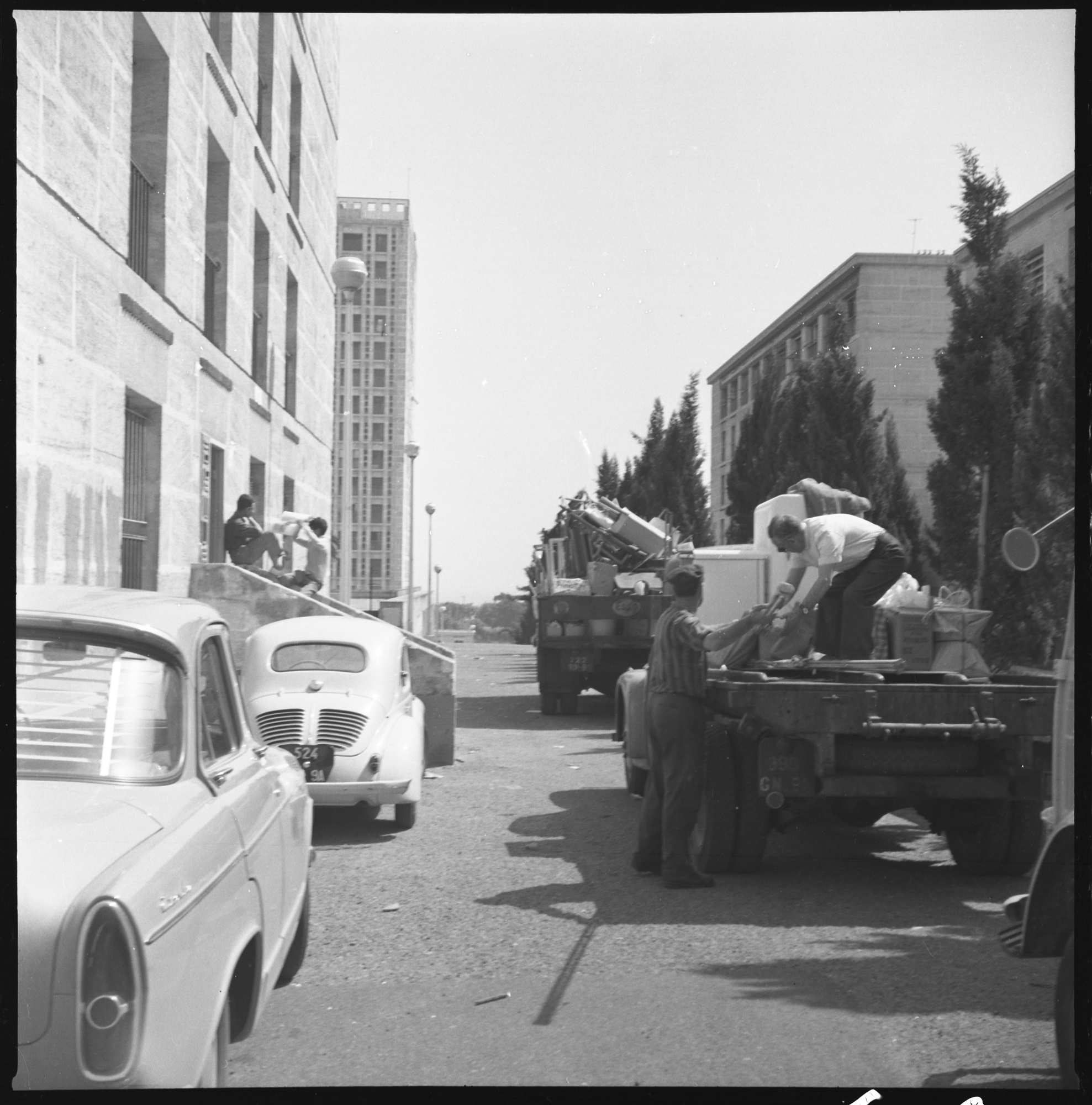 Des Européens chargent leurs meubles sur un camion dans un quartier d'Alger en juin-juillet 1962